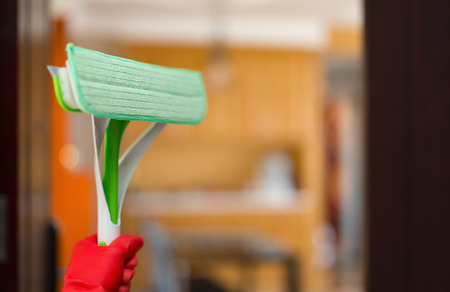 entering a house with brush and glove concept of domestic cleaning
