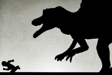 shadow of spinosaurus chasing human  on wall no logo or trademarkの写真素材