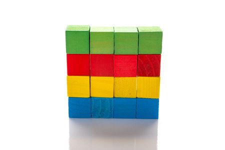 colorful wooden toy blocks stack up on a white background