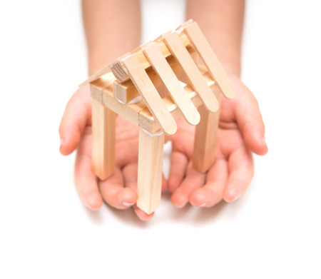 kid holds a house model on a white backgroundの写真素材