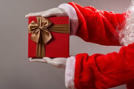 Santa Claus handing a gift box with brown bowの写真素材