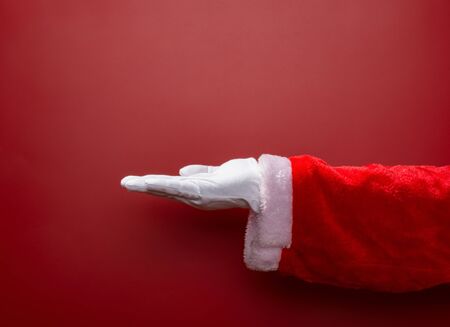 Santa Claus open his hand on red backgroundの写真素材