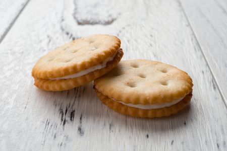 sandwich biscuits with white cream filling on white wood backgroundの写真素材