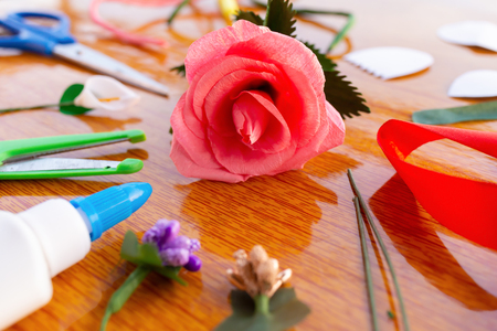 side view hand made rose with scissors tapes and glue on tableの写真素材