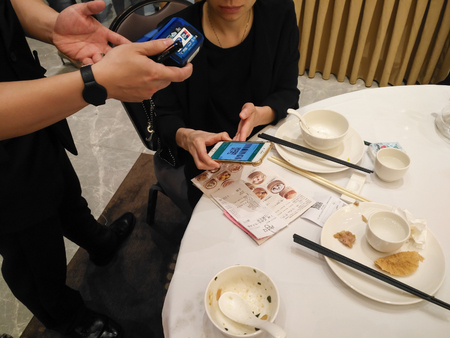 Zhongshan,China-May 13, 2018:doing payment at a restaurant via Wechat money on mobile.Wechat or Alipay for payment and money transfering via mobile becomes very common and popular in China,fast and safe.のeditorial素材