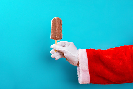 santa claus holding a red bean ice cream stick in front of a blue backgroundの写真素材