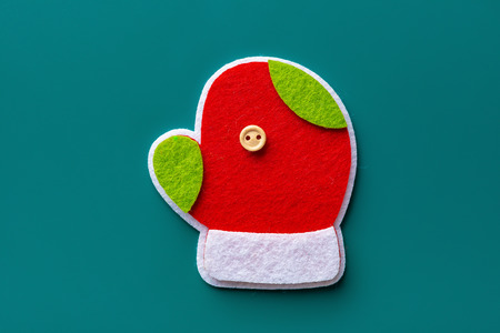 cute colorful christmas glove on a green background