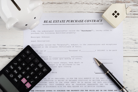 top view real estate purchase contact with a house and piggy bank and calculator and a penの写真素材