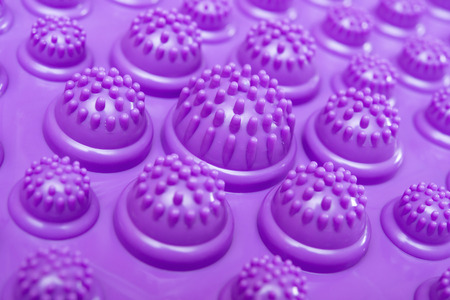 purple foot massage pad with plastic domes close up