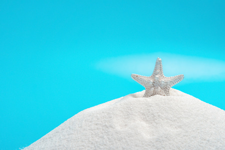 white starfish on white sand on blue background,  concept of summer vacationsの写真素材