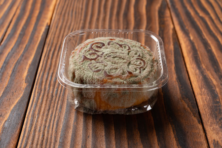 moldy mooncake on wooden background