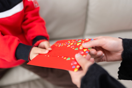 Mother giving a red pocket to her son