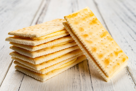 sandwich biscuits with beige cream filling on white wood backgroundの写真素材