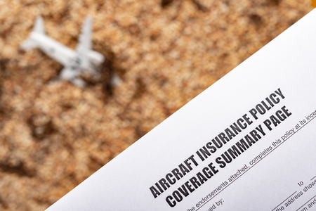 aircraft insurance policy coverage form wtih a blurred crashed aircraft model on back