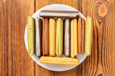 top view multicolor sandwich cookies on a wood tableの写真素材