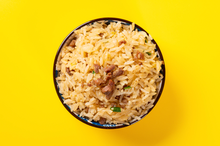 top view fried rice with beef in a bowl on yellow backgroundの写真素材