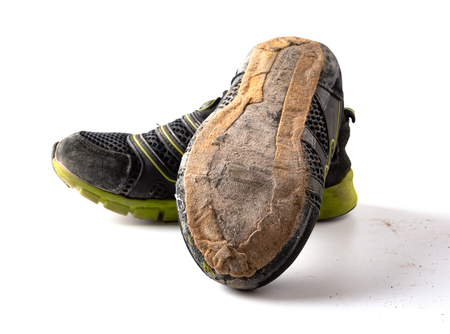 pair of broken sporty shoes on white backgroundの写真素材