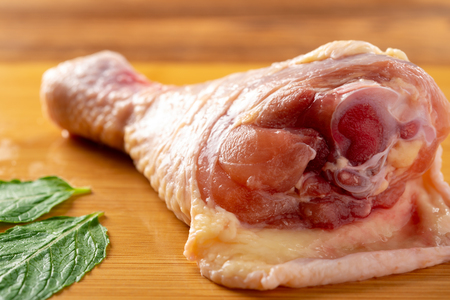 fresh raw chicken legs on a bamboo chop boardの写真素材