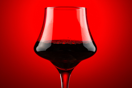 backlit cup of red wine close upの写真素材