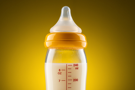 glass baby bottle with powdered milk closeupの写真素材