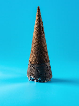 Ice cream in cone with shredded coconut upside down on blue backgroundの写真素材
