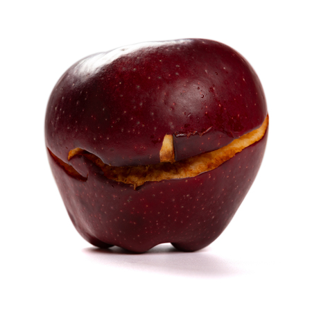 overripe apple with a crack on white backgroundの写真素材