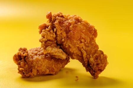 Fresh deep-fried chicken drumstick and wing on yellow backgroundの写真素材