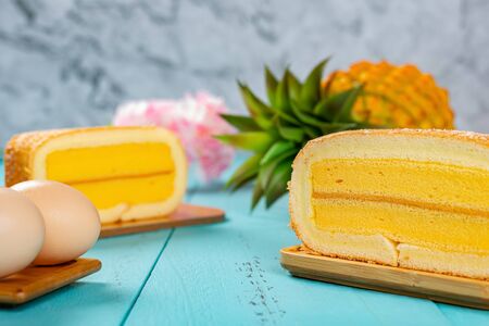 pineapple flavor sweet rolls with eggs and a pineapple on background on blue tableの写真素材