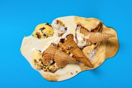 top view ice cream cones melted on a blue background