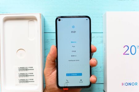 Zhongshan,China-July 19, 2019:Man setting up a brand new Honor mobile.Honor is a sub-brand of Huawei...