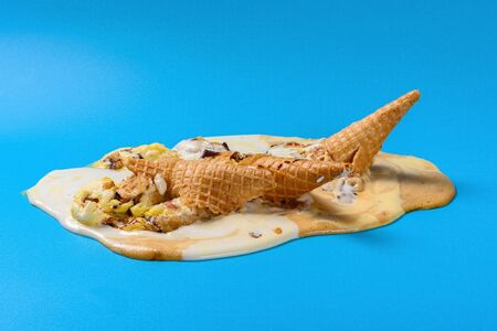 side view multiple flavor ice cream cones melted on blue background