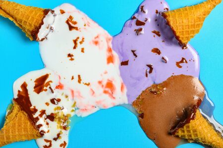 top view mini ice cream cones melted completely on a blue background