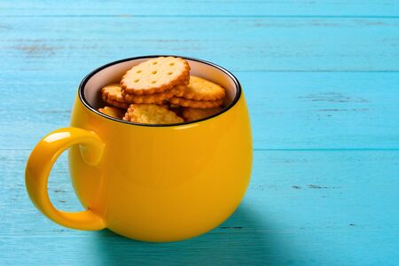 sandwich biscuits inside a cup on blue tableの写真素材
