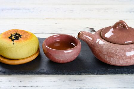 side view red bean paste cake  and cup of tea with teapot