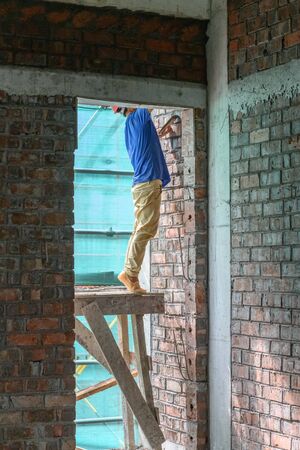 plasterer making up a brick wall vertical compositionの写真素材