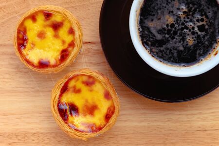 top view fresh portuguese egg tarts with cup of coffee nearbyの写真素材