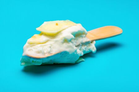 mostly eaten white chocolate outer ice cream stick on blue backgroundの写真素材