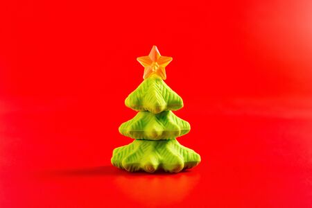 christmas decorative doll of fir tree on red backgroundの写真素材