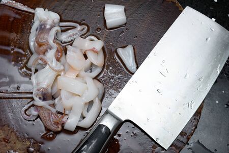 fresh raw squids  being cut in piecesの写真素材