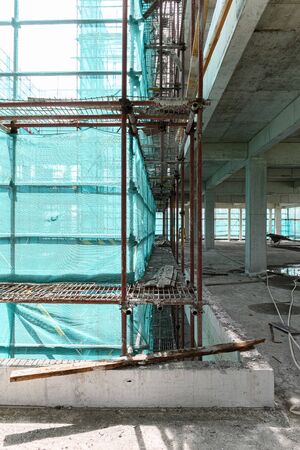 inside of an unfinished building with protection scaffolding and netting surrounded