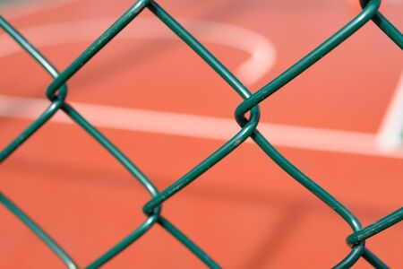 outdoor basketball court behind a metal fence horizontal compositionの写真素材