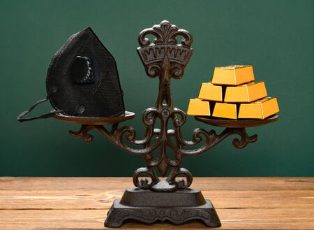 medical respirator and gold bars on a balanced scale concept of value and price for the medical...