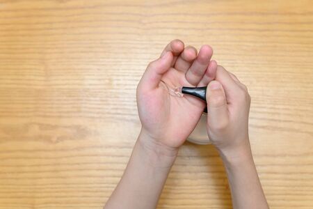 kid using instant hand sanitizer to clean his handsの写真素材
