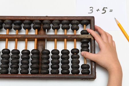kid using abacus to calculate simple addition equation