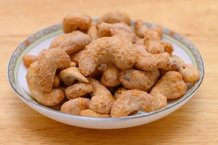 side view cashew nuts on a dish on wooden background