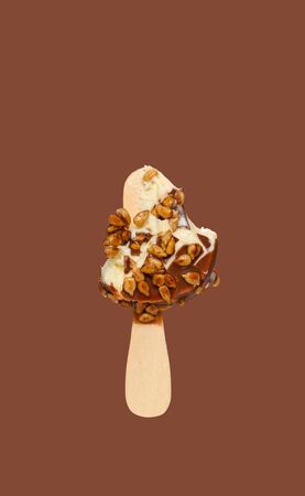 mostly eaten chocolate outer ice cream stick with melon seeds on brown background