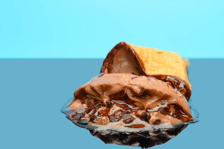 chocolate flavor ice cream cone melted on glass with reflectionの写真素材