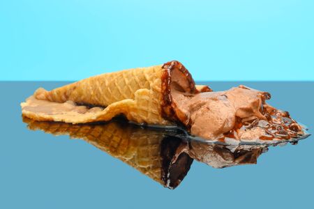chocolate flavor ice cream cone melted on glass with reflectionの写真素材