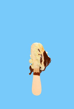 chocolate outer ice cream stick with the last bit on blue backgroundの写真素材