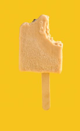 half eaten milk tea flavor ice cream stick on yellow backgroundの写真素材